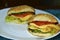Sandwiches with chicken meat tomatoes and herbs and a sesame bun