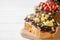 Sandwiches with chocolate paste, pistachio nuts and fresh berries on a wooden serving Board. Copy space