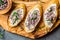 Sandwiches with cream cheese and garlic edible flowers, olive board