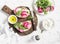 Sandwiches with feta cheese, beets and arugula on rustic cutting board on a light background.