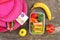 Sandwiches, fruits and vegetables in food box, backpack on old wooden background.