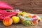 Sandwiches, fruits and vegetables in food box, backpack on old wooden background