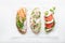 Sandwiches with ham, radish, romano salad, baby basil, mascarpone cheese, caprese salad on a white background. top view