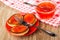 Sandwiches from pancakes with caviar in saucer, fork, spoon in bowl with imitation red caviar on napkin on table