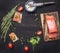 Sandwiches with pink salmon fillet, curd cheese, herbs and cherry tomatoes lined frame a black wooden background backdrop place