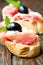Sandwiches with prosciutto olive on wooden cutting board vertical