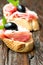 Sandwiches with prosciutto olive on wooden old table vertical