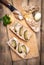 Sandwiches with rillettes, meat pate and pickled cucumber on a wooden cutting board, top view. Rustic composition.