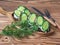 Sandwiches on rye bread toast with cream cheese and fresh cucumber with a sprig of dill on a village tray and cutlery