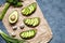 Sandwiches toast with avocado, guacamole and spinach on parchment on a concrete background. Healthy breakfast or lunch