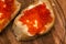 Sandwiches of white bread with butter and red caviar on a wooden board. Culinary delicacy. Red salmon caviar close-up. Seafood