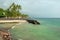 Sandy beach with azure ocean and palm trees during the storm