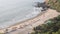 Sandy beach with beach beds and umbrellas on the background of the ocean aerial view