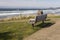 Sandy beach  bench facing to the ocean