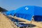 Sandy beach with blue parasols and sunbeds