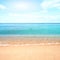 Sandy beach with calm water against blue skies.