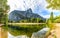 Sandy beach and clean still water of the Merced River reflect Sentinel Rock on a sunny day in Yosemite