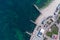 Sandy beach, concrete pier, clear sea water. Helicopter view