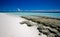 Sandy beach with corals rocks and ocean