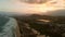 Sandy beach with dune, ocean and town with sunset lights in Campeche, Florianopolis