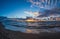 Sandy beach at dusk under a stormy sky. Seascape with waves and dramatic sky with clouds at sunset