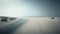 a sandy beach with footprints in the sand and a body of water in the distance.