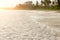 Sandy beach, green jungle, palm trees, fishing boat on the sand, swimming people