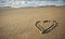 Sandy beach with a heart and waves,