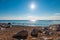 Sandy beach, large stones, blue sea and bright sun - beautiful s