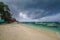 Sandy beach with moored Indonesian boats on the tropical island of Gili Meno. Heavy leaden clouds hung over the beach, a