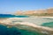 The sandy beach with pink reflections at the foot of the rocky cliffs, in Europe, Greece, Crete, Balos, By the Mediterranean Sea,