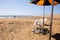 Sandy beach with plastic chairs, people and umbrella near Atlantic ocean in Maspalomas, Gran Canaria