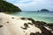 sandy beach with rocks in the foreground, sea turquoise water in the background