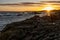 Sandy beach, with rocky outcroppings at the shoreline at sunset in Franzkraal, South Africa