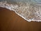 Sandy beach and a sea wave above, background