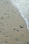 Sandy beach shoreline with an array of stones scattered along the coastline, Greece