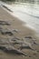 Sandy beach shoreline with an array of stones scattered along the coastline, Greece