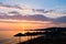 Sandy beach with stray sunshades and orange chairs at sunset in Sithonia