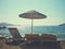 Sandy beach on a sunny afternoon, with parasols and sun loungers; retro style