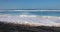 Sandy beach on sunny day with blue ocean waves in tropics