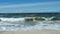 Sandy beach, waves of the blue sea, blue sky