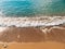 Sandy beach and waves, close-up. Texture of sand and water. Pict