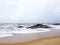 The sandy beaches of Kundapura with rocks and foamy waves