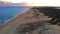 Sandy dunes beach seaside view from top. Drone point of view coastline Mediterranean Sea surf, pink bright fluffy clouds evening