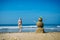 Sandy happy  man and sexy young woman on the sea beach against blue cloudy summer sky