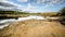 Sandy hills. Lake in the Sandy canyon. Warm colors background. Yellow sandstone textured mountain, white thin sand dune, bright sk