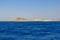 Sandy island on a rock of sandstone on the edge of desert. Military crew base overseeing naval operations. White brick house.