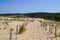 Sandy nature path way access to the beach sea with fence in summer