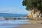 Sandy oceanic beach with cliff on side