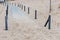 Sandy path between bollards to the beach